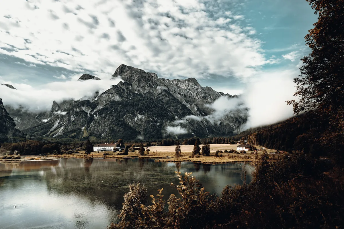 Alpine lake beneath craggy mountains and cloud cover